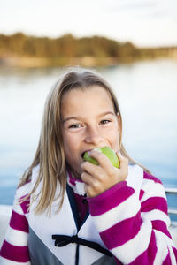 Smiling girl eating apple