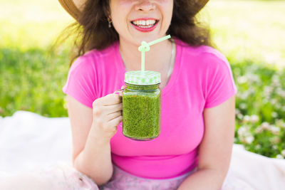 Midsection of woman drinking glass