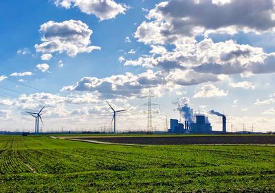 Windmills on field against sky