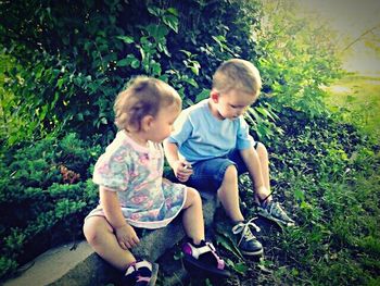 Siblings sitting on grass