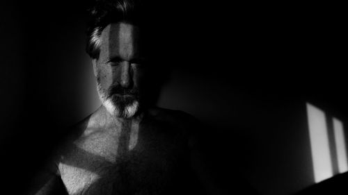 Portrait of shirtless man in darkroom