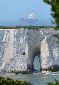 View of rock formation in sea against sky