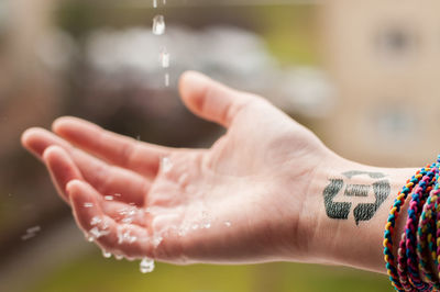 Cropped image of woman touching drops of water
