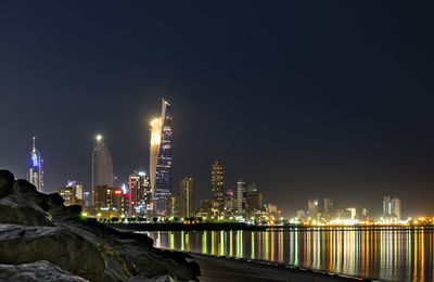 Illuminated buildings against sky at night