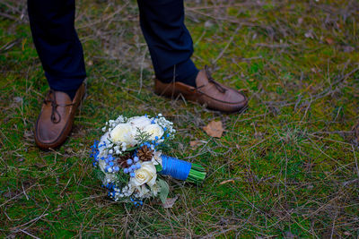 Low section of man standing on grassy field