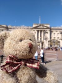 Close-up of stuffed toy in city against sky