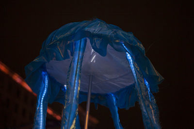 Close-up of illuminated lighting equipment against black background