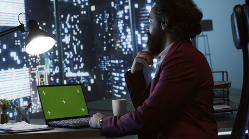 Side view of woman using laptop at home