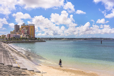 Woman from behind on the beach in the vicinity of the american village in chatan city of okinawa.