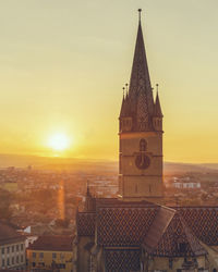 Clock tower in city against sky during sunset