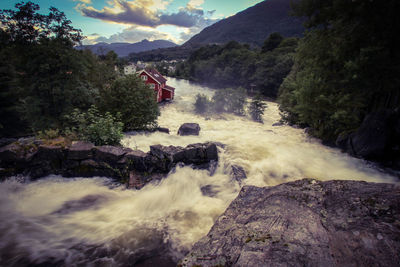 Scenic view of waterfall against sky