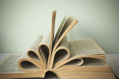 Close-up of book on table against wall