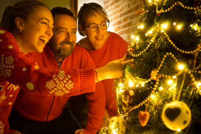 People on illuminated christmas tree