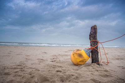 Yellow umbrella on beach against sky