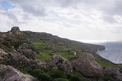 Scenic view of mountain by sea against sky