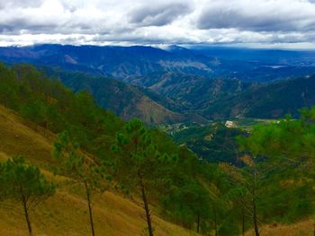 Scenic view of mountains against cloudy sky