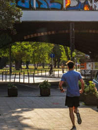 Rear view of man walking on street in city