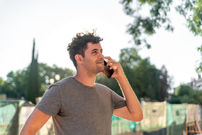 Young latin man in the city talking by mobile phone.