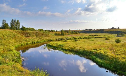 Scenic view of lake against cloudy sky
