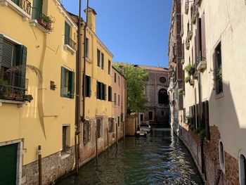 Canal amidst buildings in town against sky