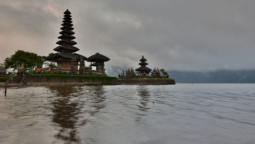 Temple by building against sky