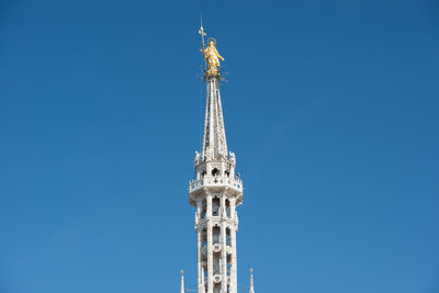 View to spires and statues on roof of duomo through ornate marble fencing. milan, italy