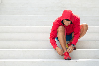 Full length of young man sitting on staircase