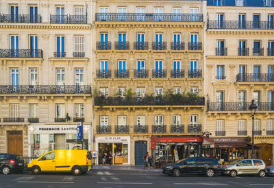 Vehicles on road by buildings in city