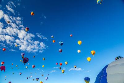 Low angle view of hot air balloons flying against sky