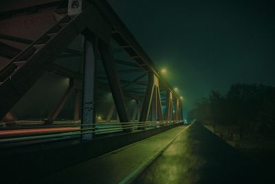 Low angle view of illuminated bridge against sky at night
