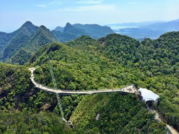 High angle view of bridge through mountains against cloudy sky