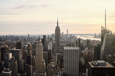 Modern buildings in city against sky during sunset