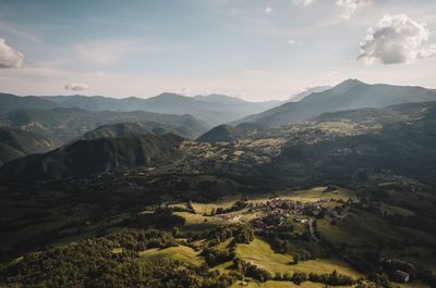 Scenic view of valley and mountains against sky