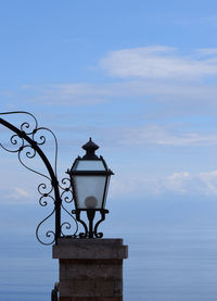 Low angle view of security camera against sky