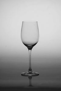 Close-up of wine glass on table against white background