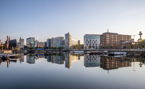 Reflection of buildings at liverpool waterfront against sky