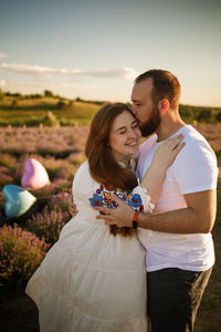 Side view of couple standing on field