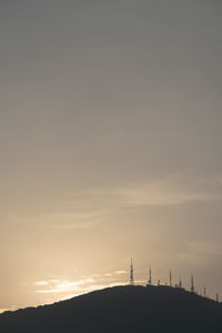 Silhouette people on field against sky during sunset