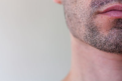 Close-up of shirtless man against white background