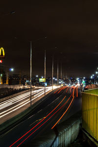 Light trails on road against sky at night