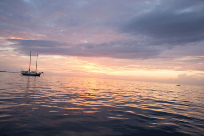 Boats in sea at sunset