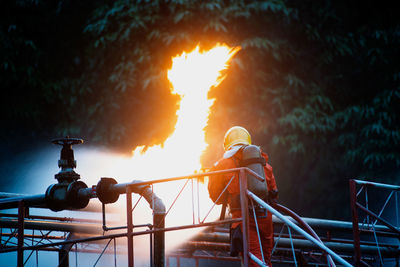 Firefighter extinguishing fire against trees