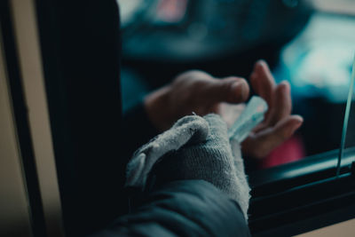 Cropped hand of person giving money through car window