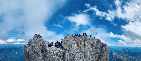 Group of people on rock against sky