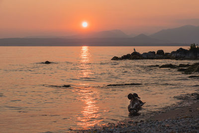 Scenic view of sea against orange sky