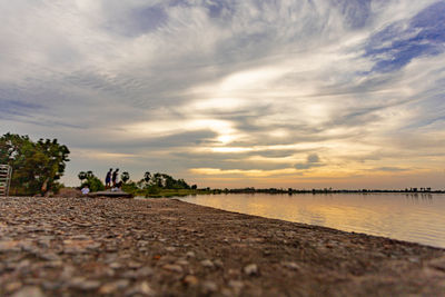 Surface level of beach against sky during sunset