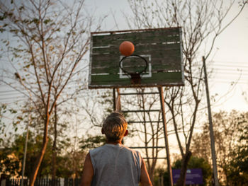Rear view of man with basketball hoop