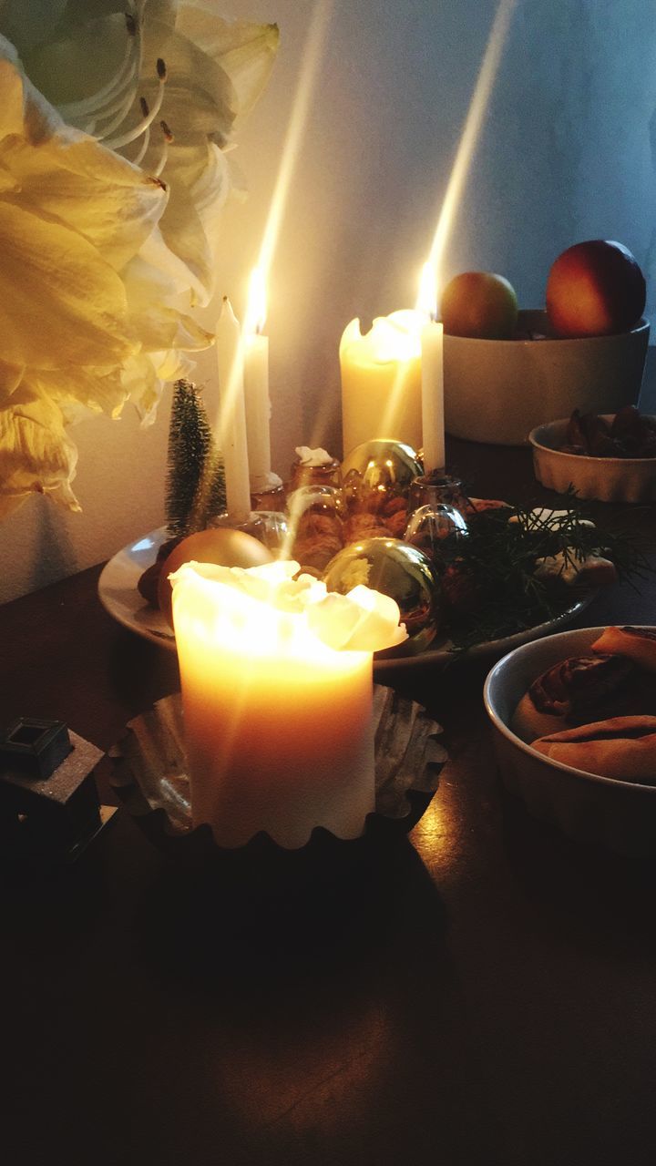 HIGH ANGLE VIEW OF LIT TEA LIGHT CANDLES ON TABLE