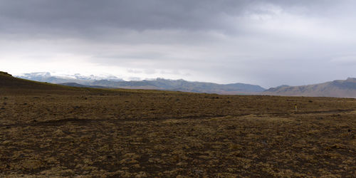 Scenic view of mountains against cloudy sky