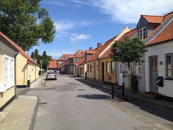 Road amidst buildings in city against sky
